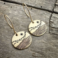 St. Mary Lake Earrings - Glacier Mountain and Lake with Sun showcasing etched brass disks with mountain designs.