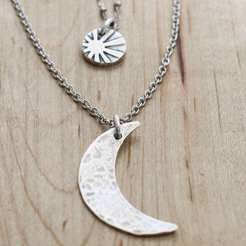 Sun and Moon Long Layered Necklace featuring a hammered crescent moon and sun on layered chains.