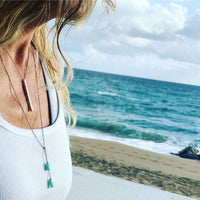 Twig Long Layered Necklace worn by a woman at the beach with ocean waves in the background.