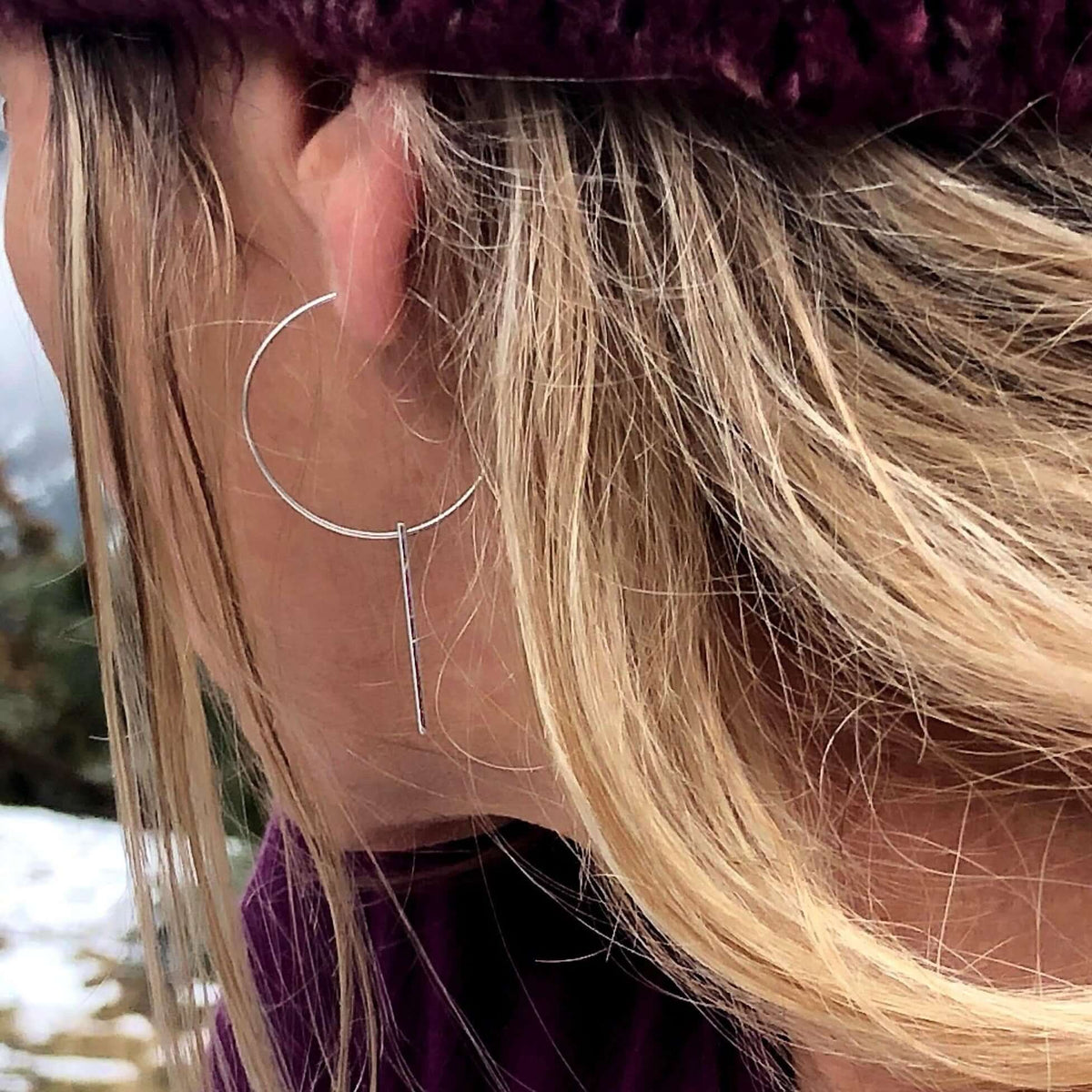 A close-up of a woman wearing Twigs Hoop Earrings in Matte Silver, featuring a clean and elegant design.