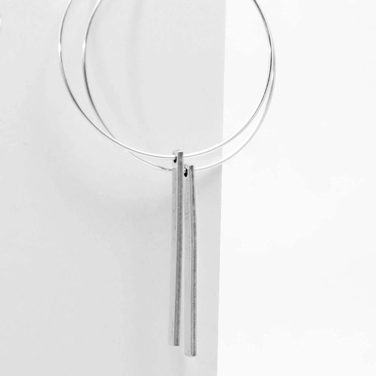 Twigs Hoop Earrings featuring clean and simple design with two twig components in matte silver finish.