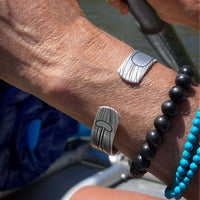 Upstream Cuff Bracelet - Paddle River Rafting Adventure worn on wrist with abstract waves and paddle design.
