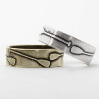 Upstream Paddle Ring set featuring silver and bronze designs with paddle engravings.