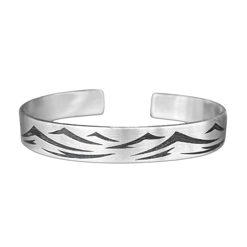 Waves Cuff Bracelet featuring intricate wave patterns in matte silver finish, adjustable fit for any wrist size.