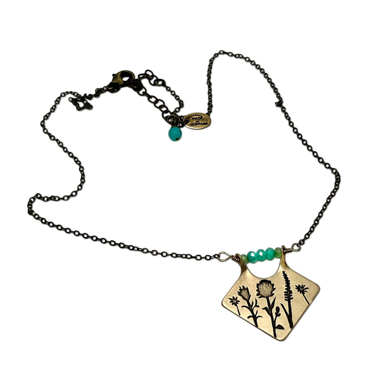 Wildflower Box Necklace featuring a floral design and colored stones, symbolizing new beginnings from the Rocky Mountains.