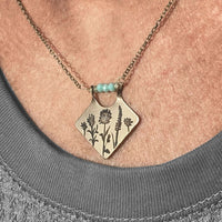 Wildflower Box Necklace featuring engraved flowers and colored stones, perfect for celebrating new beginnings.
