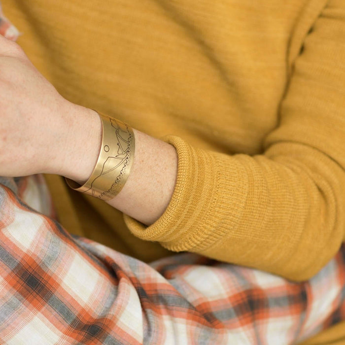 Yosemite Wide Cuff Bracelet- worn on a wrist, featuring a scenic design in antique brass finish.